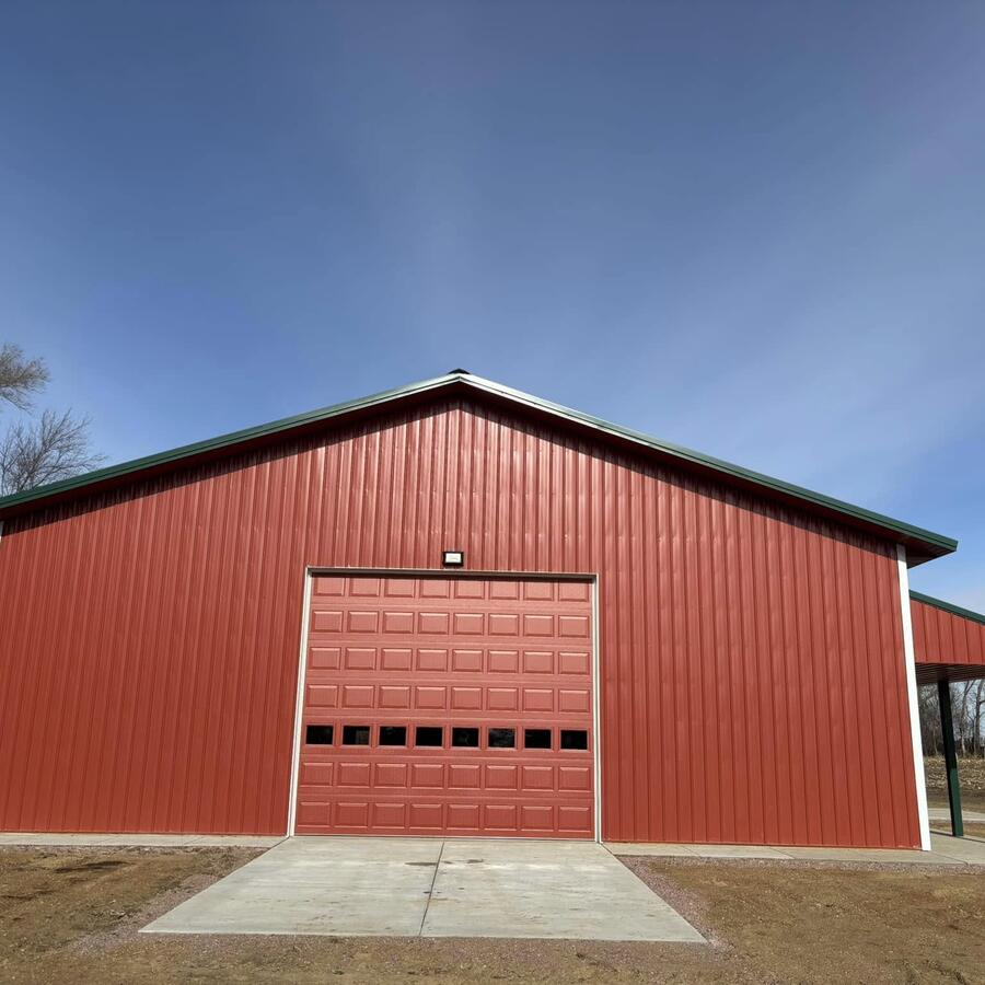 Finished red pole shed with overhead garage door