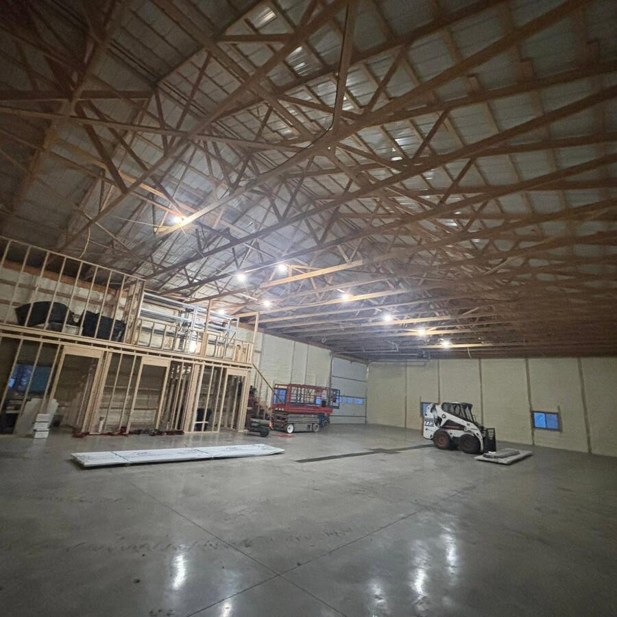 Finished shop interior with trusses, lighting, and concrete floor